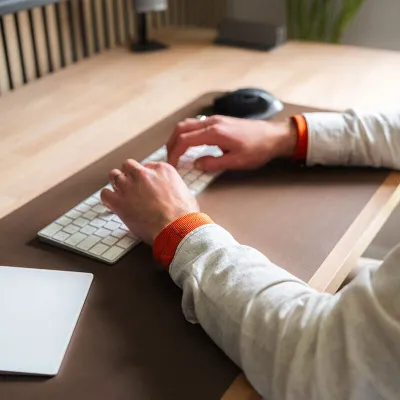 man works at the office and does sport with discreet weighted bracelets - gentle gymnastics on chair - essential shaking