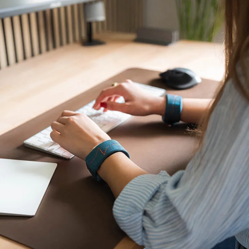 woman at the office with discreet weight training device - wrist weights - works against essential tremors - weighted bracelets