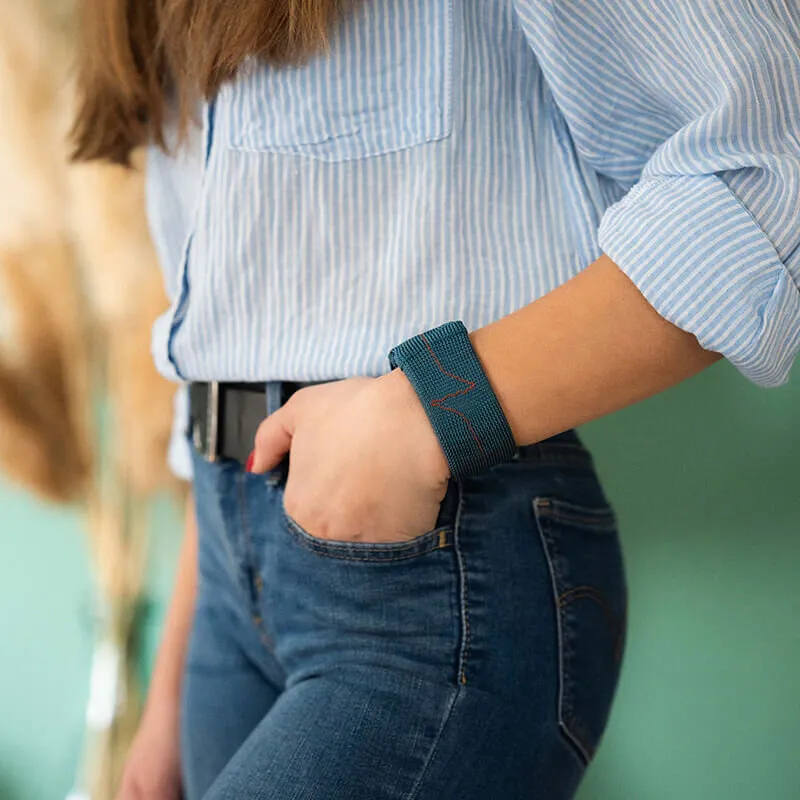 muscle-building accessory - wrist weight in blue on a well dressed woman - exercise discreetly at the office - weights for arm