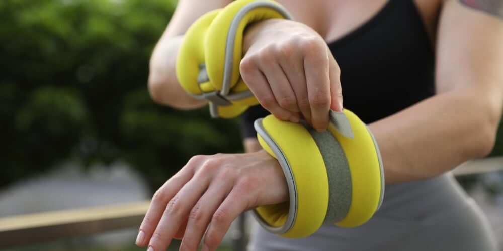 Woman putting on her weighted bracelets sand-weight-bracelets